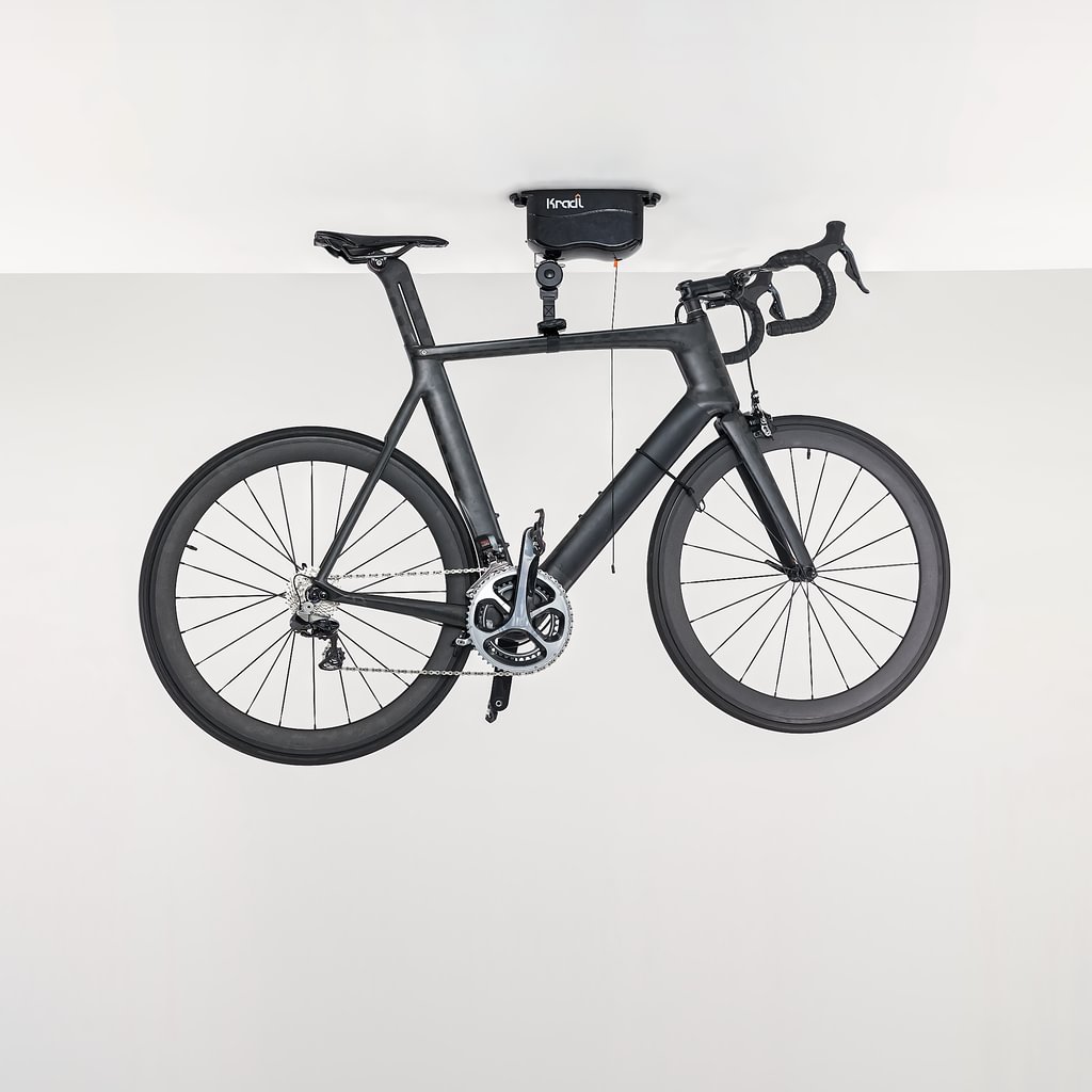 Black road bike hanging from Kradl